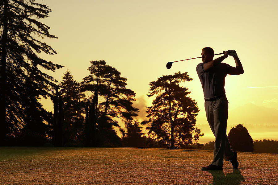 Golfer Swinging Club On Golf Course At Photograph by Thomas Northcut