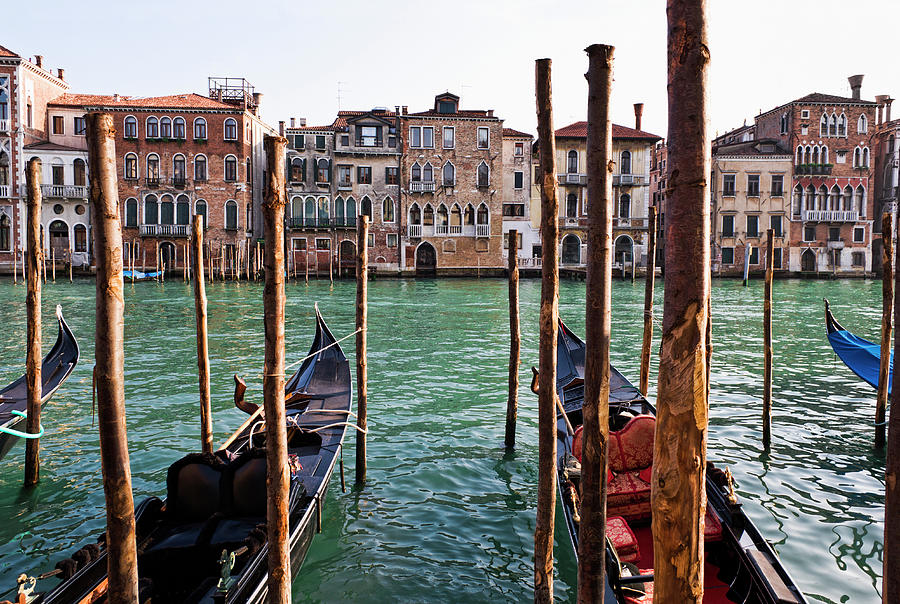 Gondolas Moored In Canal On Wooden Posts Photograph by Pbnj Productions