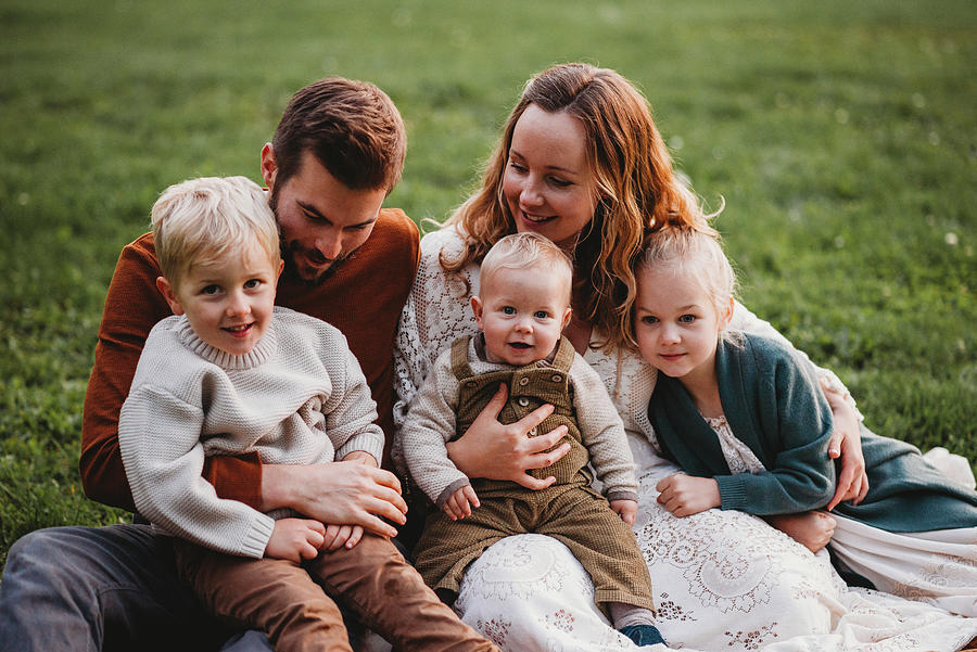 Good Looking Smiling Family Sitting In A Park Photograph by Cavan ...