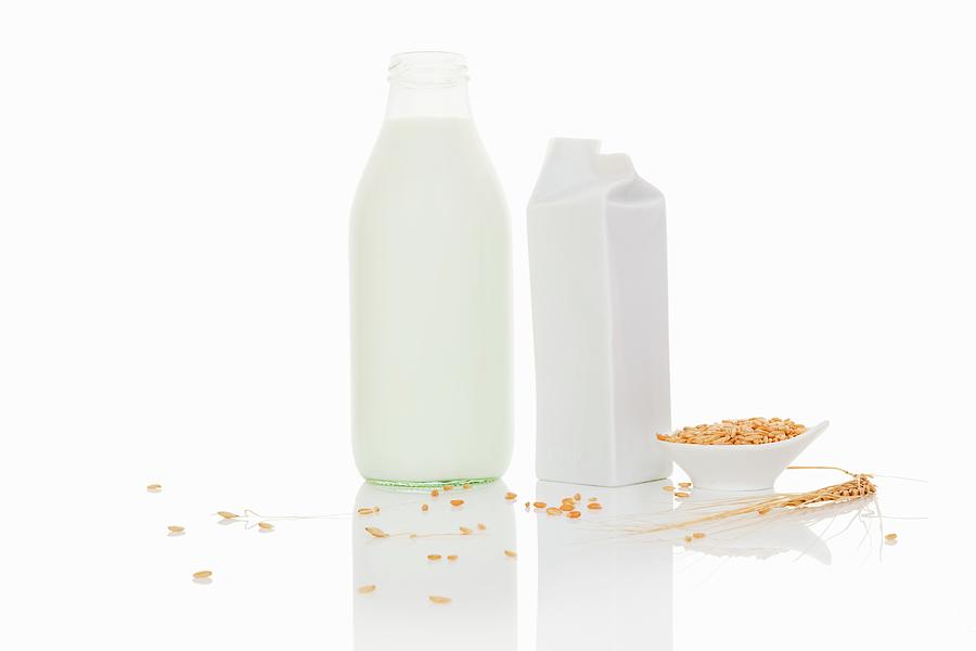 Grain Milk In A Bottle And A Carton On A White Surface Photograph by Martina Kovacova