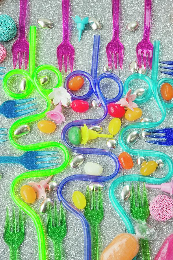 Graphic Overview Of Coloured Plastic Party Forks And Blue And Purple Curved Drinking Straws On A Silver Glittery Background With Sweets Photograph by Burgess, Linda