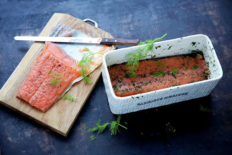 Graved Lax Being Made: Marinated Salmon Fillets In A Rectangular Container With Spices And Dill And On A Chopping Board Photograph by Sabine Mader