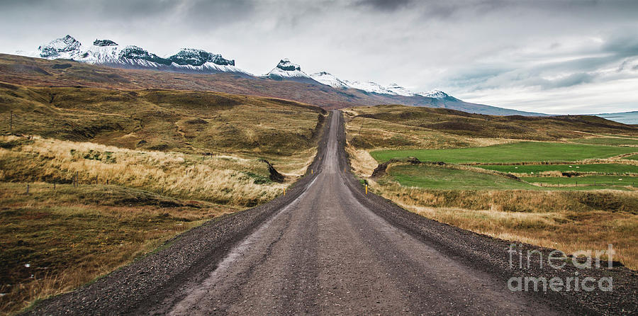 Gravel road in the snowy mountains of Iceland after a rainy day with mud Photograph by Joaquin Corbalan