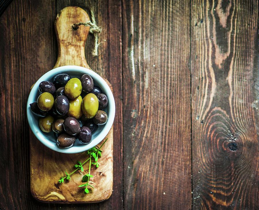 Green And Black Olives In A Dish On A Chopping Board seen From Above Photograph by Alena Haurylik