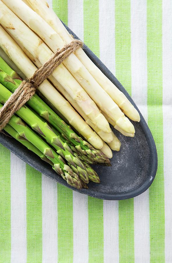 Green And White Asparagus, Tied In Bundles, On A Plate Photograph by Uwe Merkel