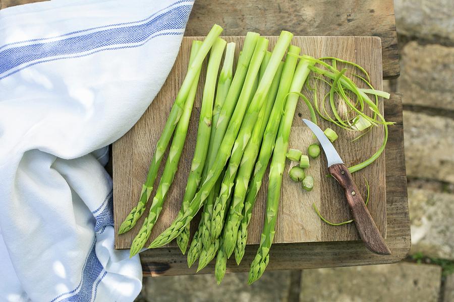 Green Asparagus On A Chopping Board With A Knife Photograph by Sabine Steffens