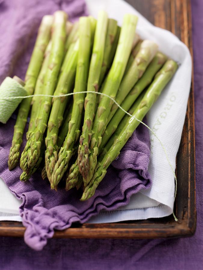 Green Asparagus On A Purple Cloth Photograph by Eising Studio - Food Photo & Video