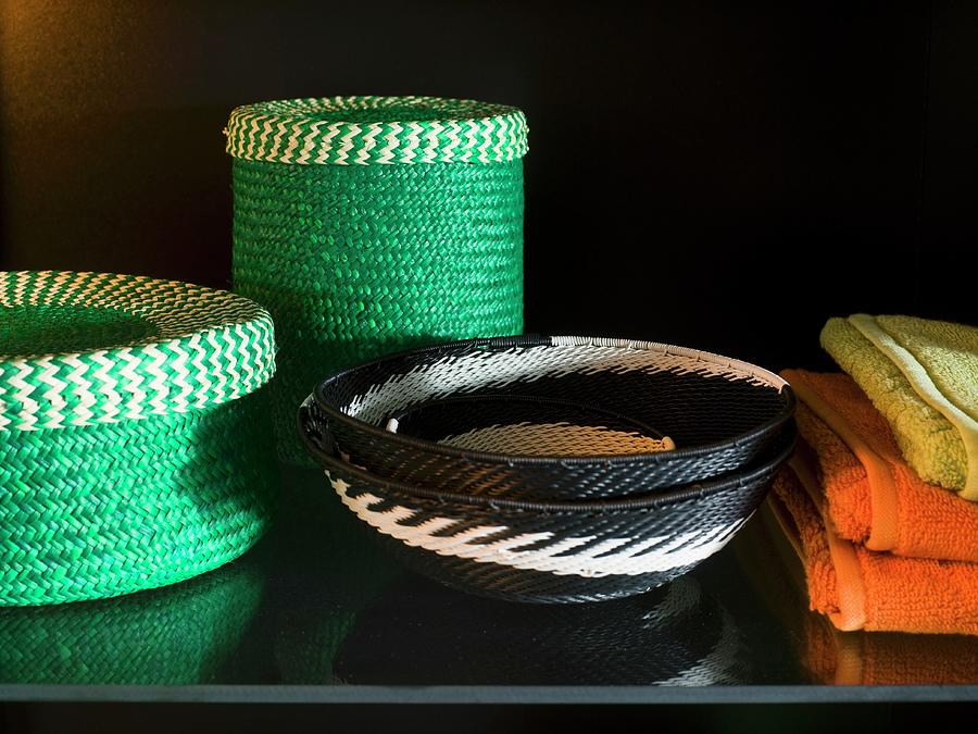 Green Basket Set Next To Black And White Patterned Wicker Bowls On A Black Surface Photograph by Per Magnus Persson