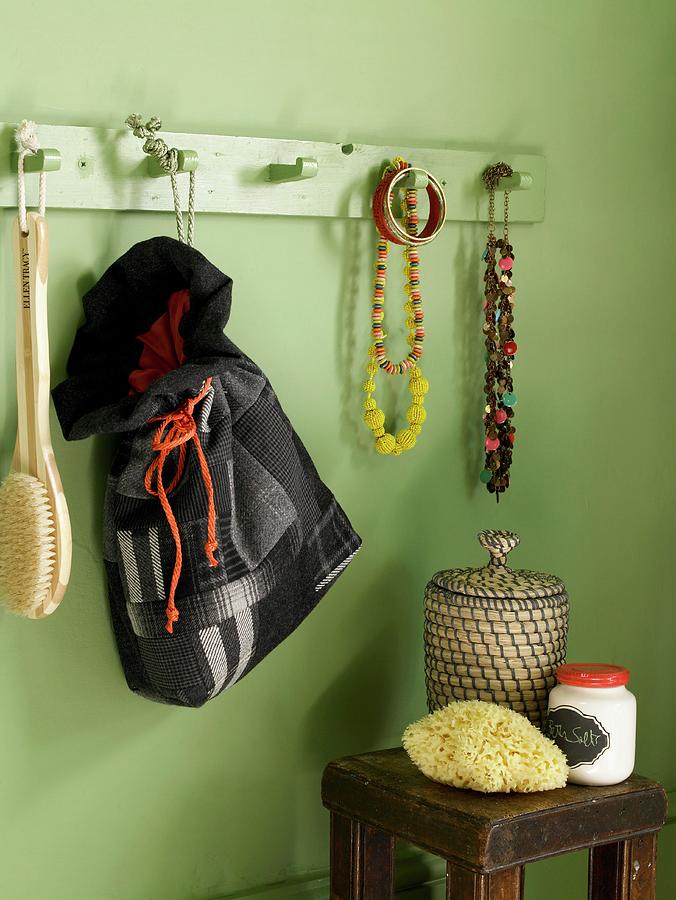 Green Bathroom Wall With Wooden Wall Coat Rack With Jewelry Hanging From It And A Homemade Fabric Tote Bag; Underneath An Antique Side Table Photograph by Jo Tyler