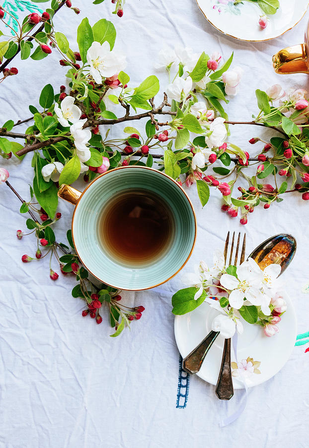 Green Cup Of Tea With Blossom On The Table And Cutlery Photograph by Lucie Beck