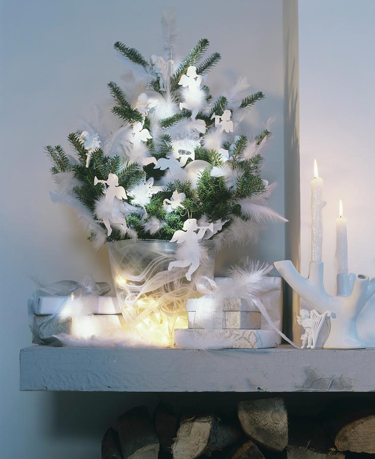 Green Fir Branches Decorated With White Feathers And Angel Ornaments In Glass Vase Photograph by Matteo Manduzio