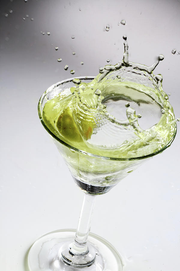 Green Olive Splashing In Martini Photograph by Visage