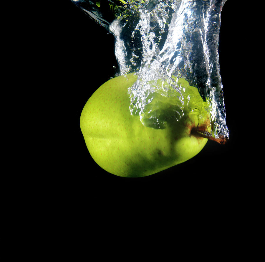 Green Pear Sinking In Water Photograph by Henrik Sorensen