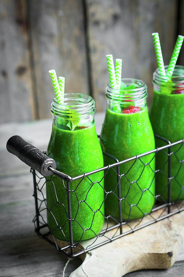 Green Smoothies And Small Glass Bottles Garnished With Raspberries Photograph by Alena Haurylik
