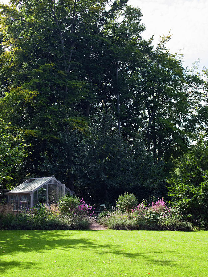 Greenhouse And Herbaceous Borders In Front Of Tall Trees Photograph by Birgitta Wolfgang Bjornvad