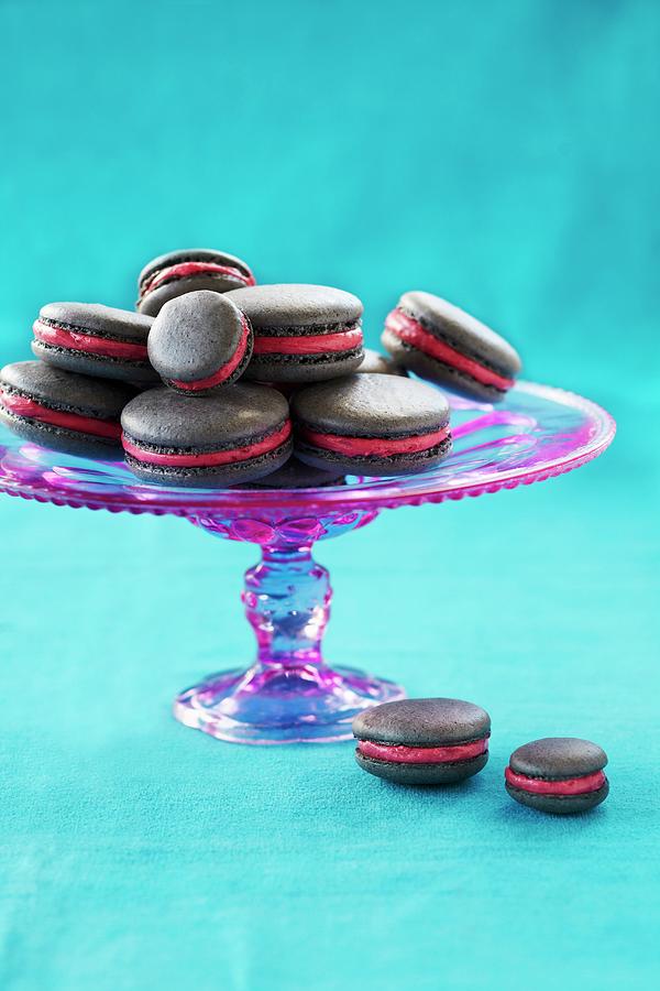 Grey Macarons With A Red Fondant Filling On A Cake Stand Photograph by Charlotte Tolhurst
