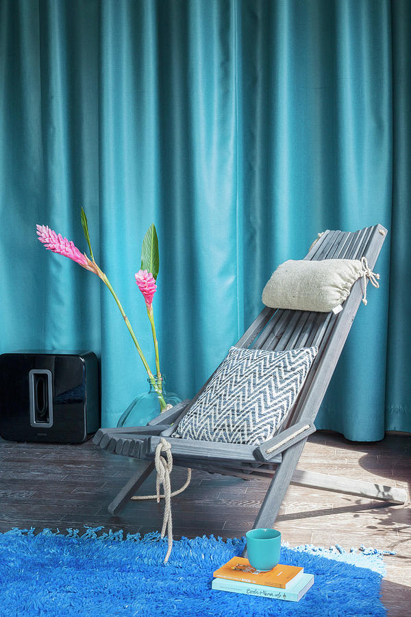 Grey Wooden Chair And Pink Flowers In Front Of Blue Curtain Photograph by Anne-catherine Scoffoni