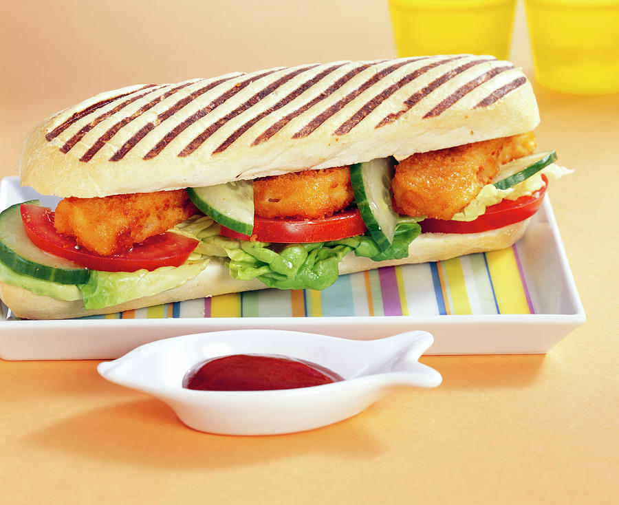 Grilled Baguette Sandwich With Baked Fish, Tomatoes, Cucumber, Lettuce And Ketchup Photograph by Teubner Foodfoto