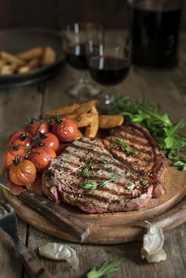 Grilled Beef Steak With Tomatoes And Chips On A Wooden Plate Photograph by Magdalena Hendey