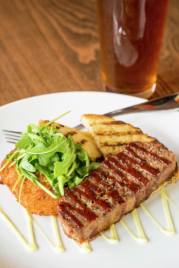 Grilled Bread With Meatloaf And Rocket On A Plate In Front Of The Glass Of Beer Photograph by Farrell Scott