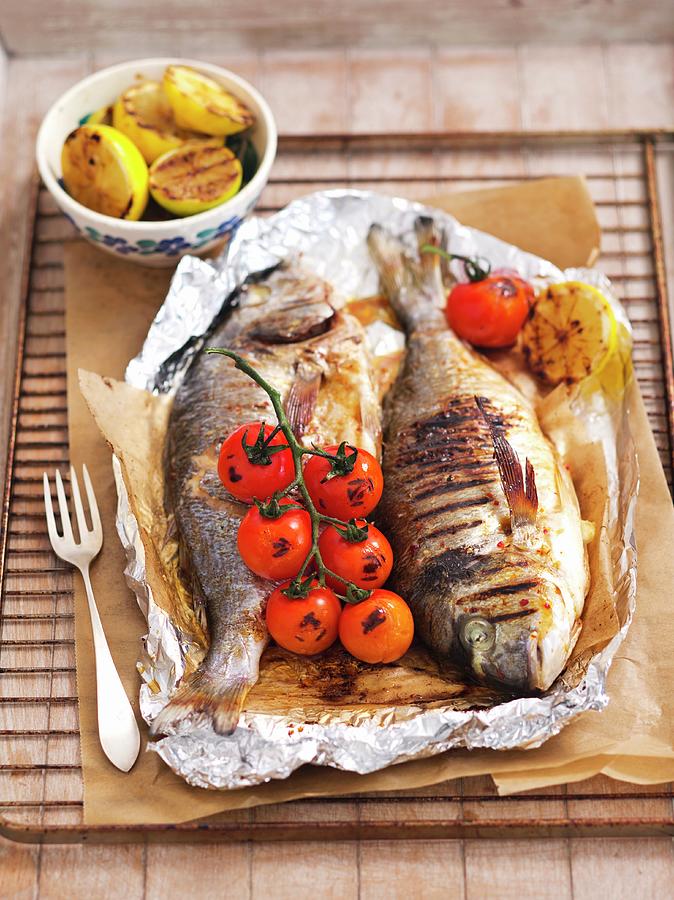 Grilled Fish With Tomatoes And Lemons In Aluminium Foil On A Grill Rack Photograph by Rua Castilho