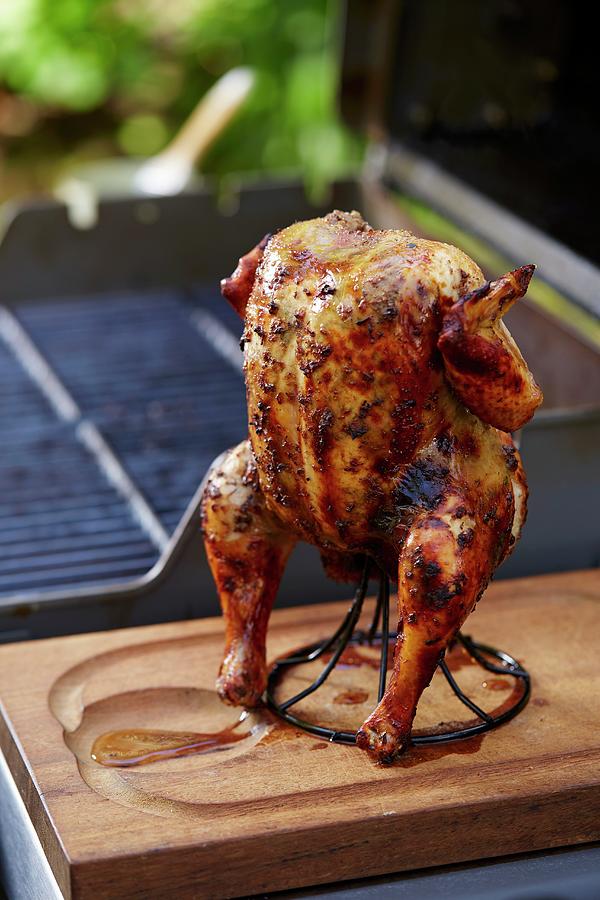 Grilled Jerk Chicken On A Stand In Front Of A Barbecue Photograph by Leigh Beisch