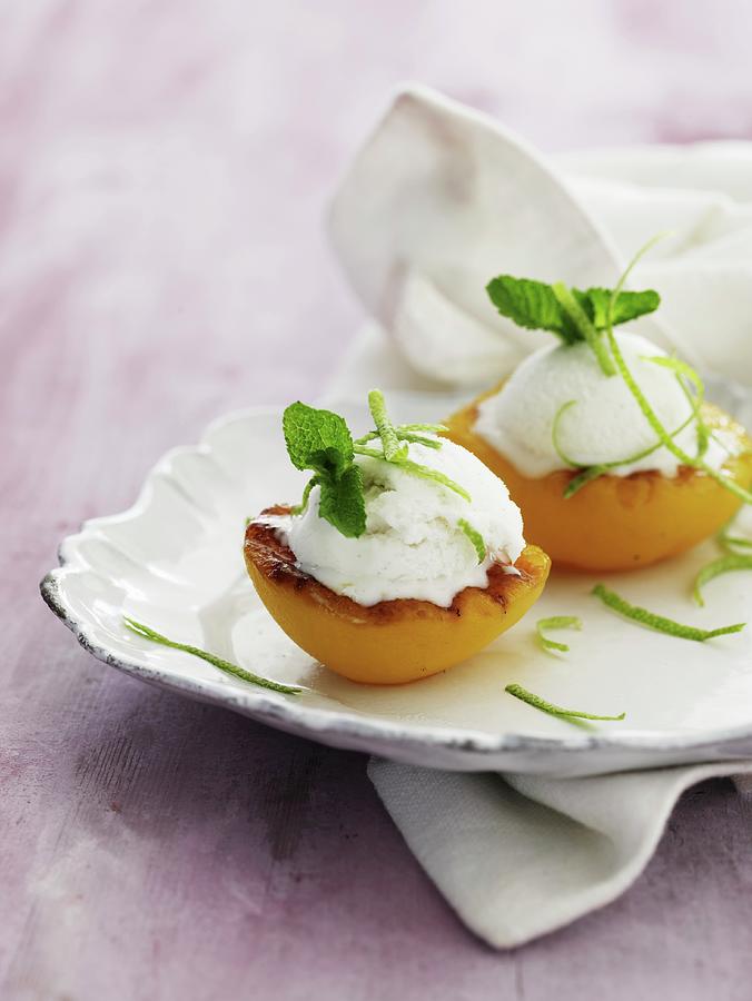 Grilled Peaches With Ice Cream, Lime Zest And Lemon Balm Photograph by Mikkel Adsbl