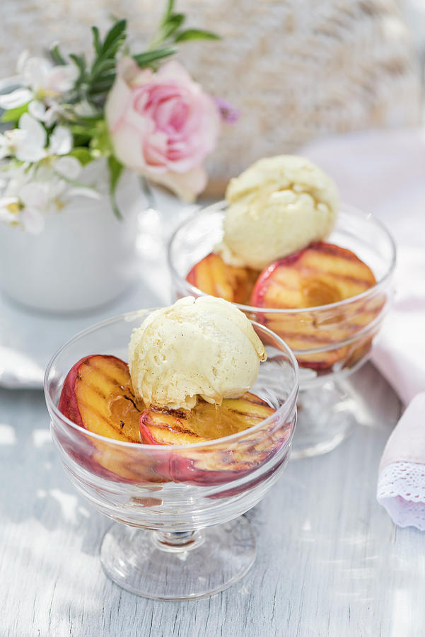 Grilled Peaches With Vanilla Ice Cream In Dessert Bowls On A Summer Table Outside Photograph by Winfried Heinze