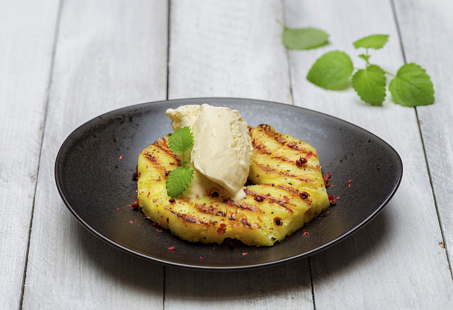 Grilled Pineapple With Pink Pepper, Vanilla Ice Cream And Lemon Balm Photograph by Nils Melzer