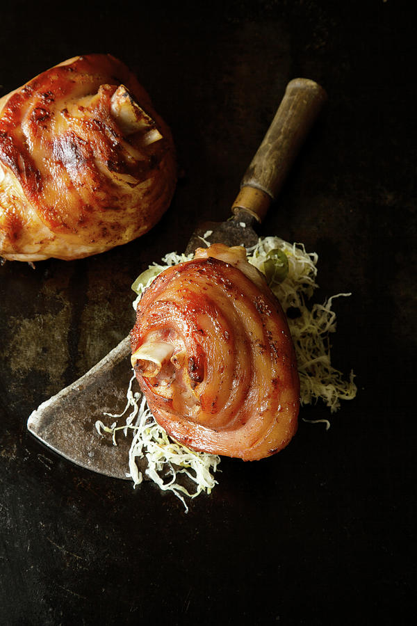 Grilled Pork Knuckles With Sauerkraut On A Meat Cleaver Photograph by