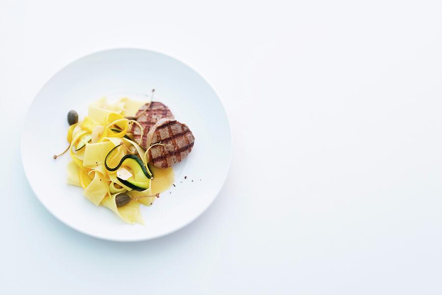 Grilled Pork Medallions With Courgette Pasta And Lemon And Caper Butter Photograph by Michael Wissing