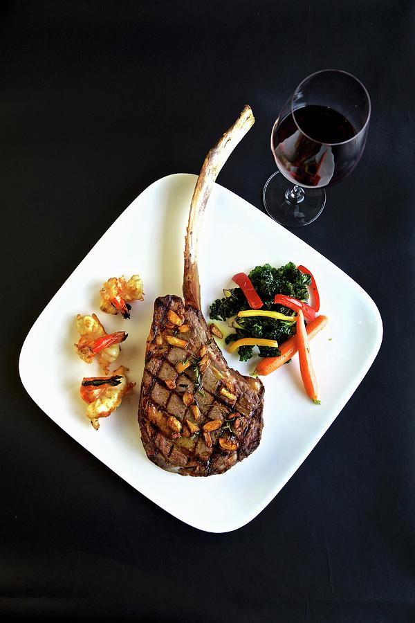 Grilled Tomahawk Steak With Sides And A Glass Of Red Wine seen From