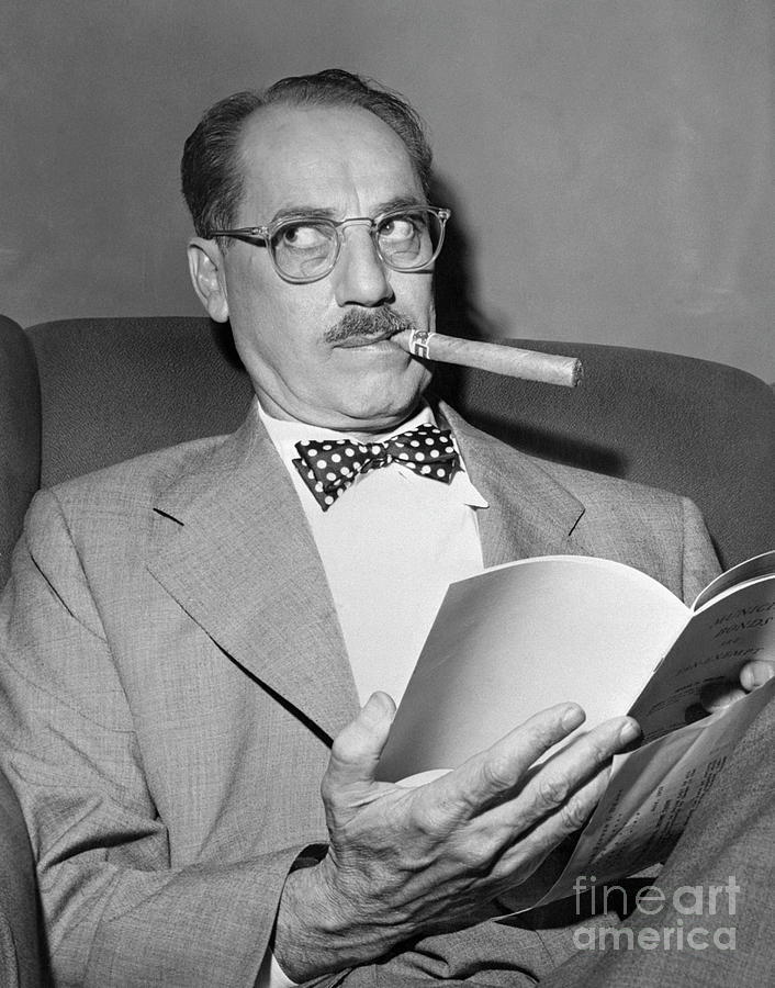 Groucho Marx Seated And Smoking Cigar Photograph by Bettmann