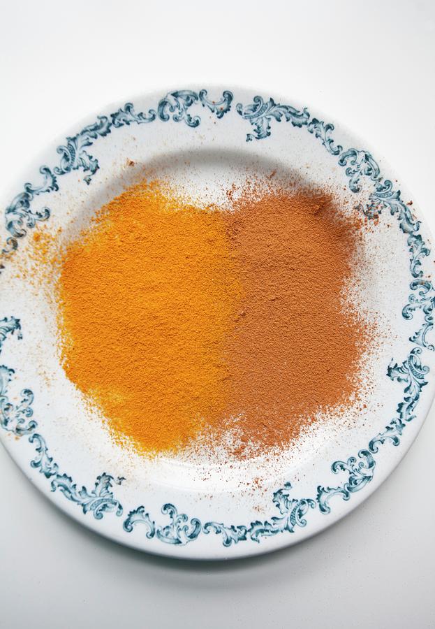 Ground Cinnamon And Ground Turmeric On A Blue And White Plate Photograph by Ryla Campbell