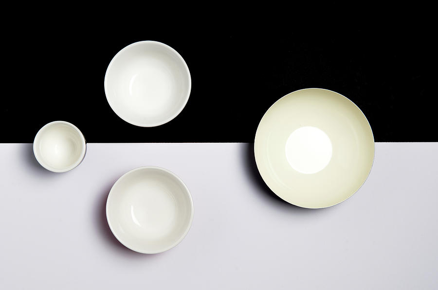 Group of empty ceramic bowls of  on a black and white surface Photograph by Michalakis Ppalis