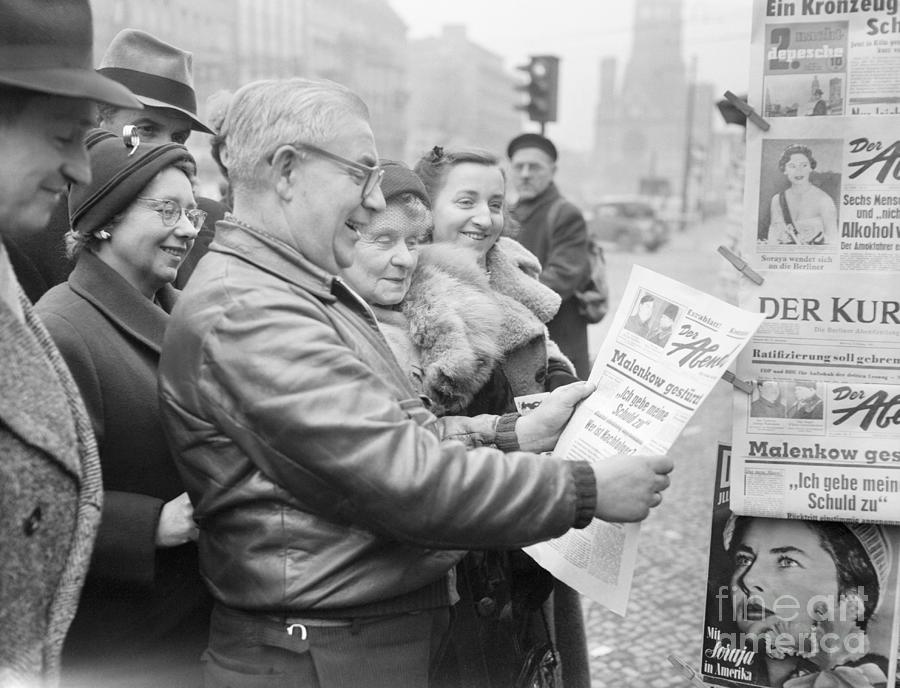 Group Reading Newspaper Photograph by Bettmann