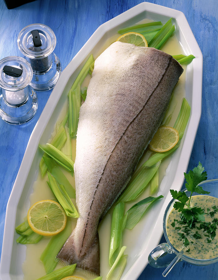 Haddock With Parsley Sauce, Leek And Lemon Slices In Serving Dish