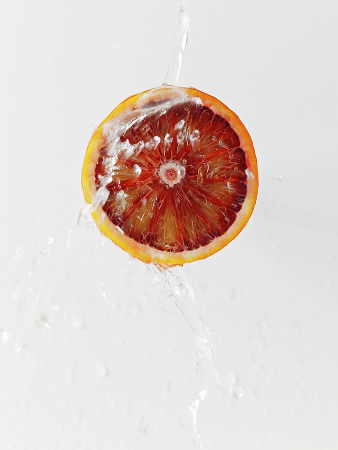 Half A Blood Orange Being Sprayed With A Jet Of Water Photograph by Luzia Ellert