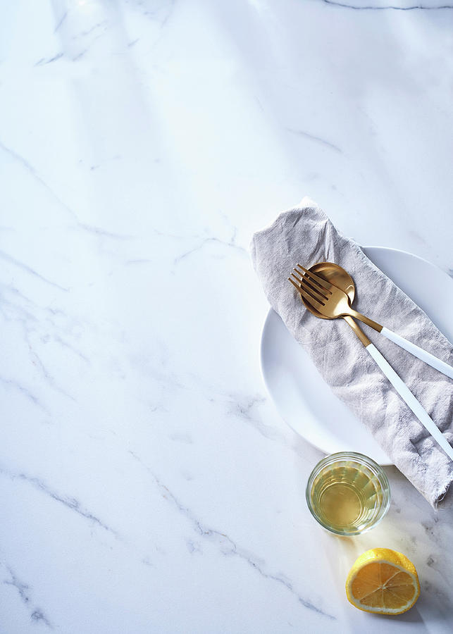 Half A Lemon, Avocado Oil In A Glass, And Salad Servers On A Napkin Photograph by Great Stock!