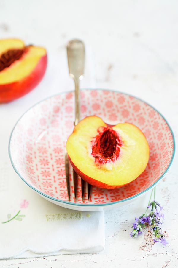 Half A Peach In A Bowl With A Fork Photograph by Claudia Gargioni