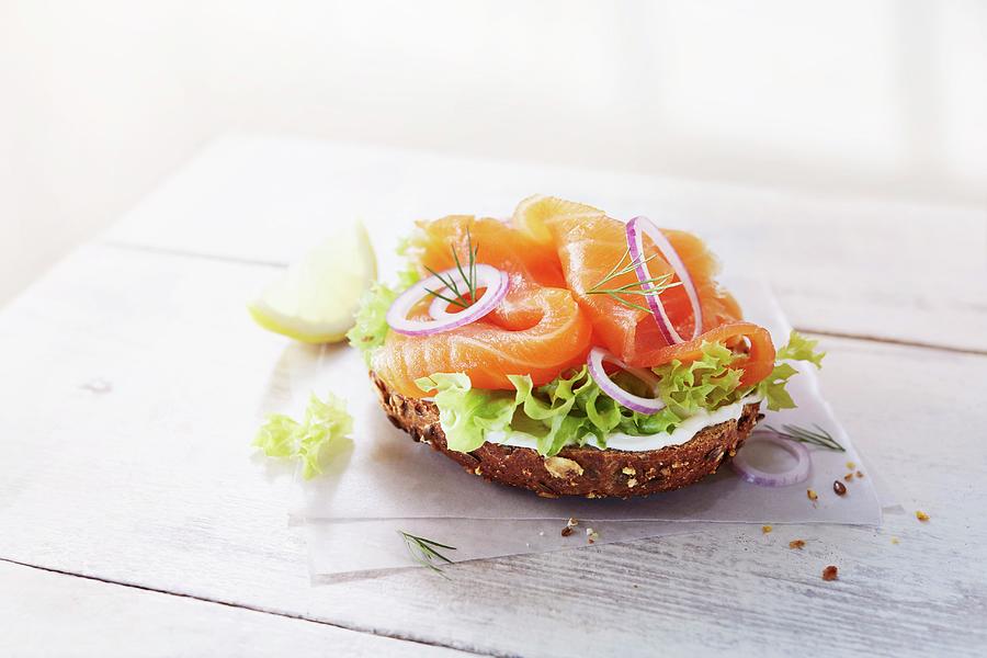 Half A Wholemeal Roll Topped With Smoked Salmon, Lettuce, Onions And Creamy Horseradish Photograph by Thorsten Kleine Holthaus