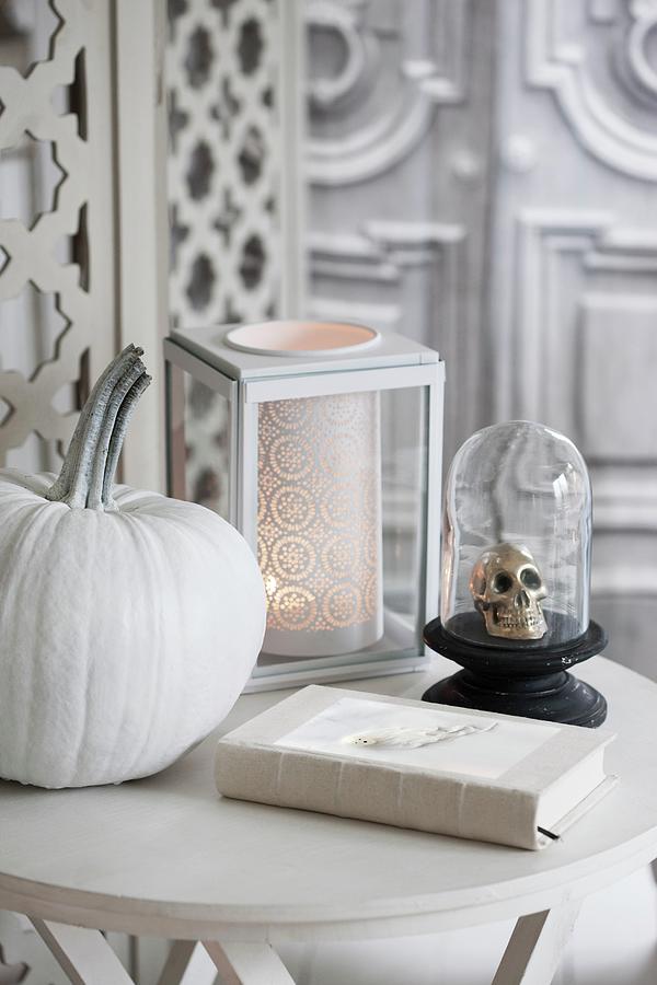 Halloween Arrangement Of White-painted Pumpkin, Skull Ornament Under Glass Cover And Romantic Candle Lantern On Table Photograph by Annette Nordstrom