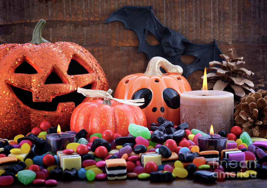 Halloween Candy with pumpkins on dark wood background.  Photograph by Milleflore Images