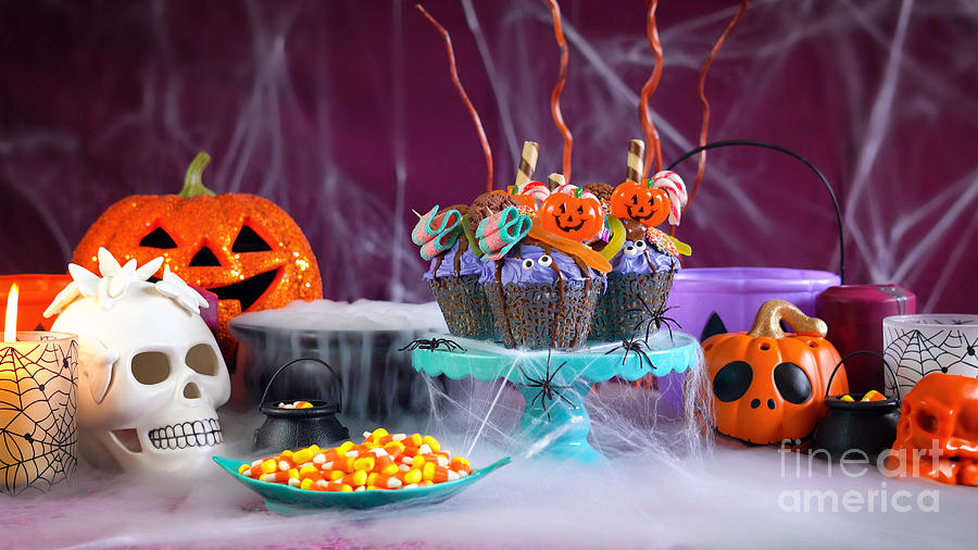 Halloween candyland drip cake style cupcakes in party table setting. Photograph by Milleflore Images