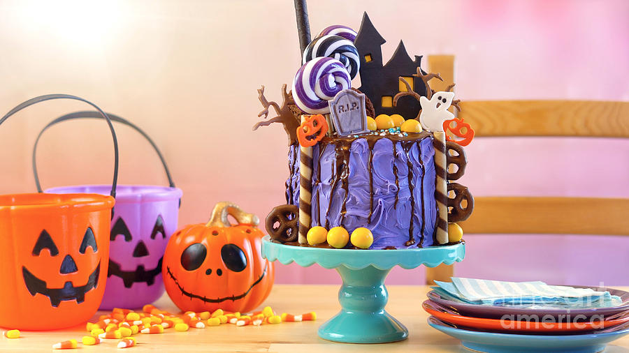 Halloween candyland novelty drip cake in colourful party setting. Photograph by Milleflore Images