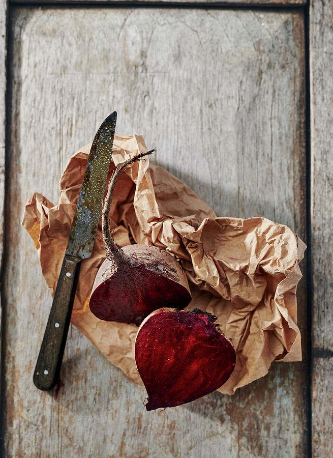 Halved Beetroot On A Board With Brown Paper And A Knife Photograph by Stefan Schulte-ladbeck