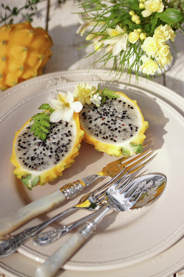 Halved Yellow Dragon Fruit With Silver Cutlery On A Plate Photograph by Angelica Linnhoff