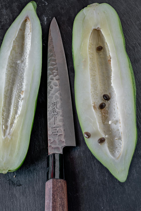 Halved, Young Papaya With A Knife On A Black Surface Photograph by Dr. Martin Baumgrtner