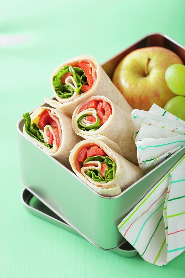 Ham And Pepper Wraps And Fruit In A Lunch Box Photograph by Olga Miltsova
