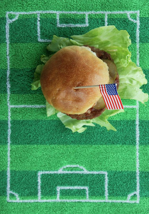 Soccer Photograph - Hamburger With A Us Flag On A Football-field Mat by Schindler, Martina